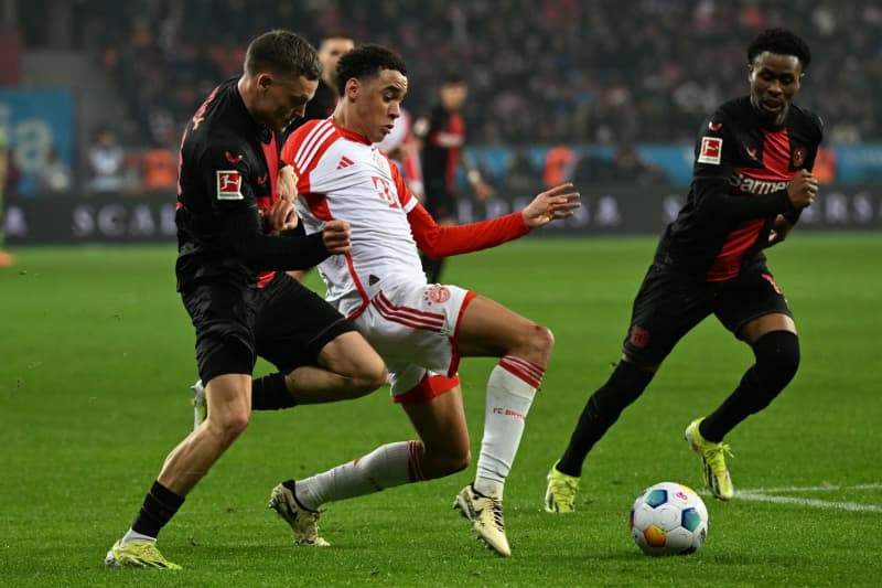 Bayer Leverkusen's Florian Wirtz (L) and Bayern Munich's Jamal Musiala battle for the ball during the German Bundesliga soccer match between Bayer Leverkusen and Bayern Munich at BayArena. Federico Gambarini/dpa