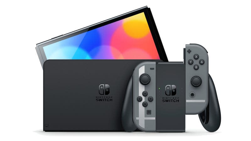 The Nintendo Switch OLED model peaks out of its dock with the Joy-Con controller sitting in front of it.