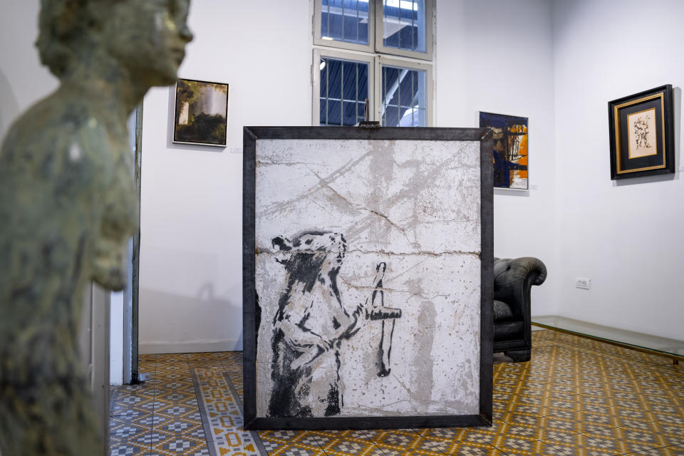 A painting by the secretive British graffiti artist Banksy that was mysteriously transferred from the occupied West Bank is revealed in Urban Gallery in Tel Aviv, Israel, Thursday, Aug. 4, 2022. The painting of a slingshot-toting rat once stood near Israel's separation barrier and was one of several works created in 2007 that protest Israel's decades-long occupation of territories the Palestinians want for a future state. (AP Photo/Oded Balilty)