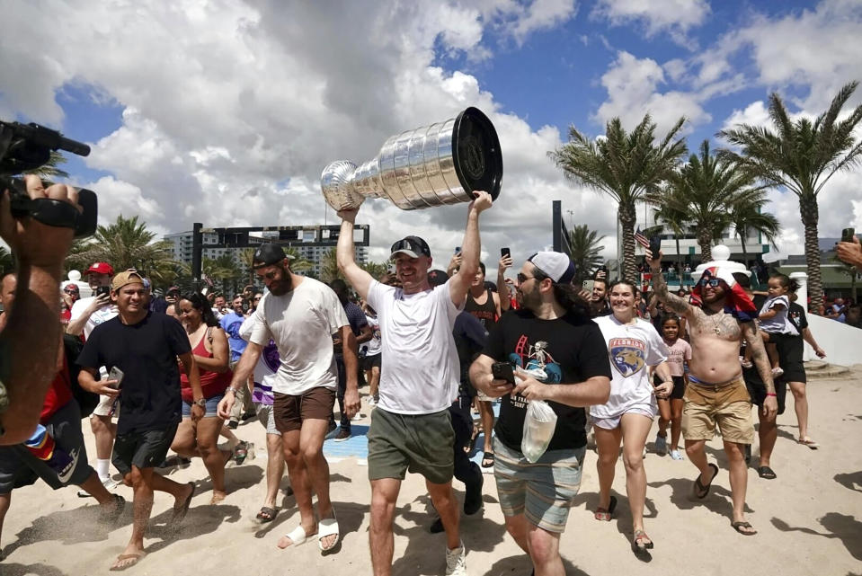 Florida Panthers NHL hockey player Sam Bennett heads to the Atlantic Ocean with the Stanley Cup in Fort Lauderdale, Fla., Tuesday, June 25, 2024. The Panthers beat the Edmonton Oilers 2-1 on Monday night in Game 7 of the Stanley Cup Final. (Joe Cavaretta/South Florida Sun-Sentinel via AP)