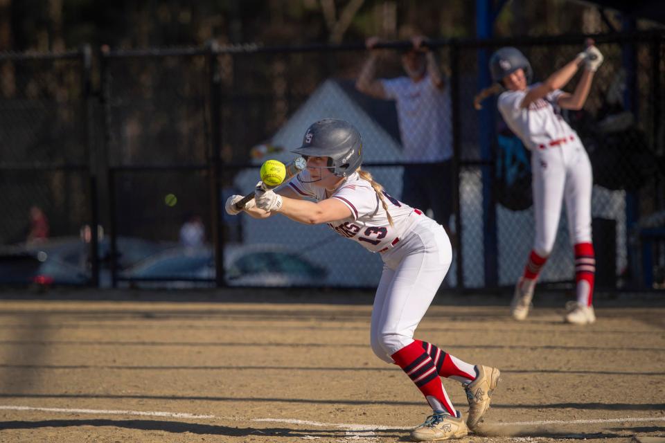Lincoln-Sudbury junior Grace Messina lays down a bunt during the game against Holliston in Sudbury, April 13, 2023. 
