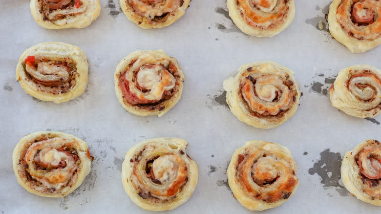 baked muffuletta pinwheels on sheet pan