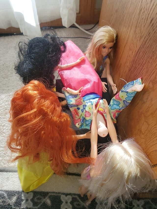 Barbies arranged to seem like they're ganging up on one Barbie