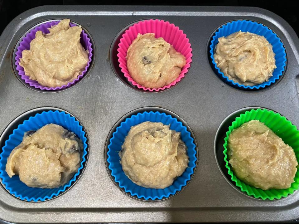 Muffin batter in a lined muffin pan.