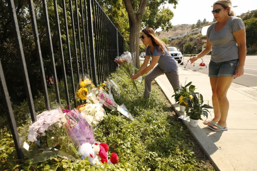 WESTLAKE VILLAGE, CA - SEPTEMBER 30: Two women in tears place flowers at a growing memorial for two brothers who were fatally injured while crossing Triunfo Canyon Road at Saddle Mountain Drive in their Westlake Village neighborhood with their family at 7:10 pm Tuesday evening. Rebecca Grossman, 57, a co-founder of the Grossman Burn Foundation was arrested on two counts of vehicular manslaughter in the death of the two juvenile pedestrians that were in the crosswalk and is being held on $2 million bail. Westlake Village on Wednesday, Sept. 30, 2020 in Westlake Village, CA. (Al Seib / Los Angeles Times