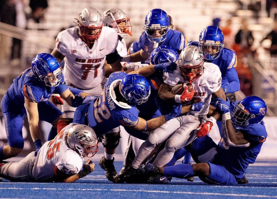 A host of Broncos take down New Mexico running back Aaron Dumas in the second half Saturday at Albertsons Stadium.