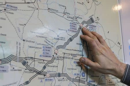 An employee shows gas transit pipelines on a map at the Romny gas compressor station in Sumy region October 16, 2014. Picture taken October 16, 2014. REUTERS/Valentyn Ogirenko