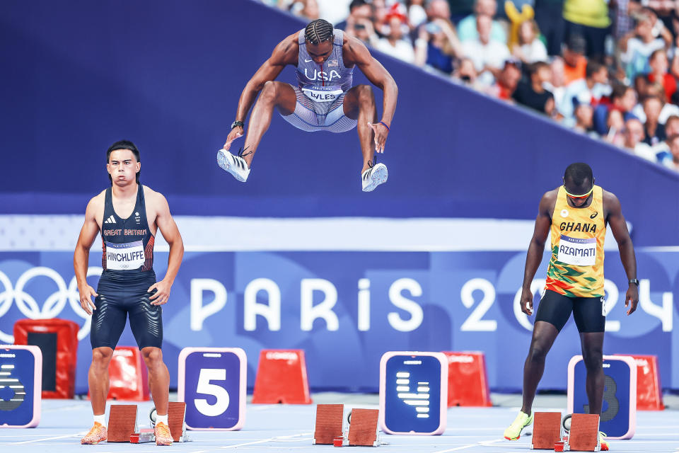 Noah Lyles memamerkan lompatannya saat pemanasan untuk semifinal lari 100 meter hari Minggu. (Christian Petersen/Getty Images)