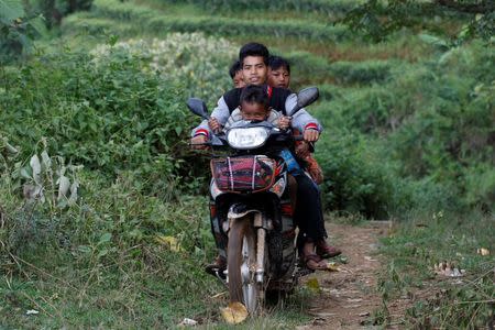 People drive their motor bike as they travel outside Pansang, Wa territory in northeast Myanmar October 3, 2016. REUTERS/Soe Zeya Tun