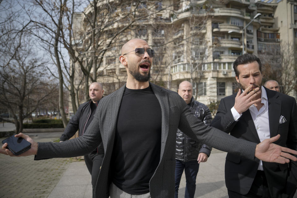 FILE - Andrew Tate gestures as he arrives at the Bucharest Tribunal in Bucharest, Romania, Monday, Feb. 26, 2024. A court in Romania's capital on Friday, April 26, 2024, ruled that a trial can start in the case of influencer Andrew Tate, who is charged with human trafficking, rape and forming a criminal gang to sexually exploit women.(AP Photo/Vadim Ghirda, File)