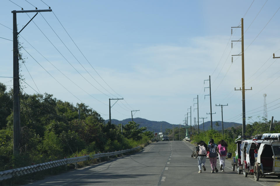 Students run along an almost empty road at the coastal town of Santa Ana, Cagayan province, northern Philippines on Tuesday, May 7, 2024. The United States and the Philippines, which are longtime treaty allies, have identified the far-flung coastal town of Santa Ana in the northeastern tip of the Philippine mainland as one of nine mostly rural areas where rotating batches of American forces could encamp indefinitely and store their weapons and equipment within local military bases under the Enhanced Defense Cooperation Agreement, or EDCA. (AP Photo/Aaron Favila)