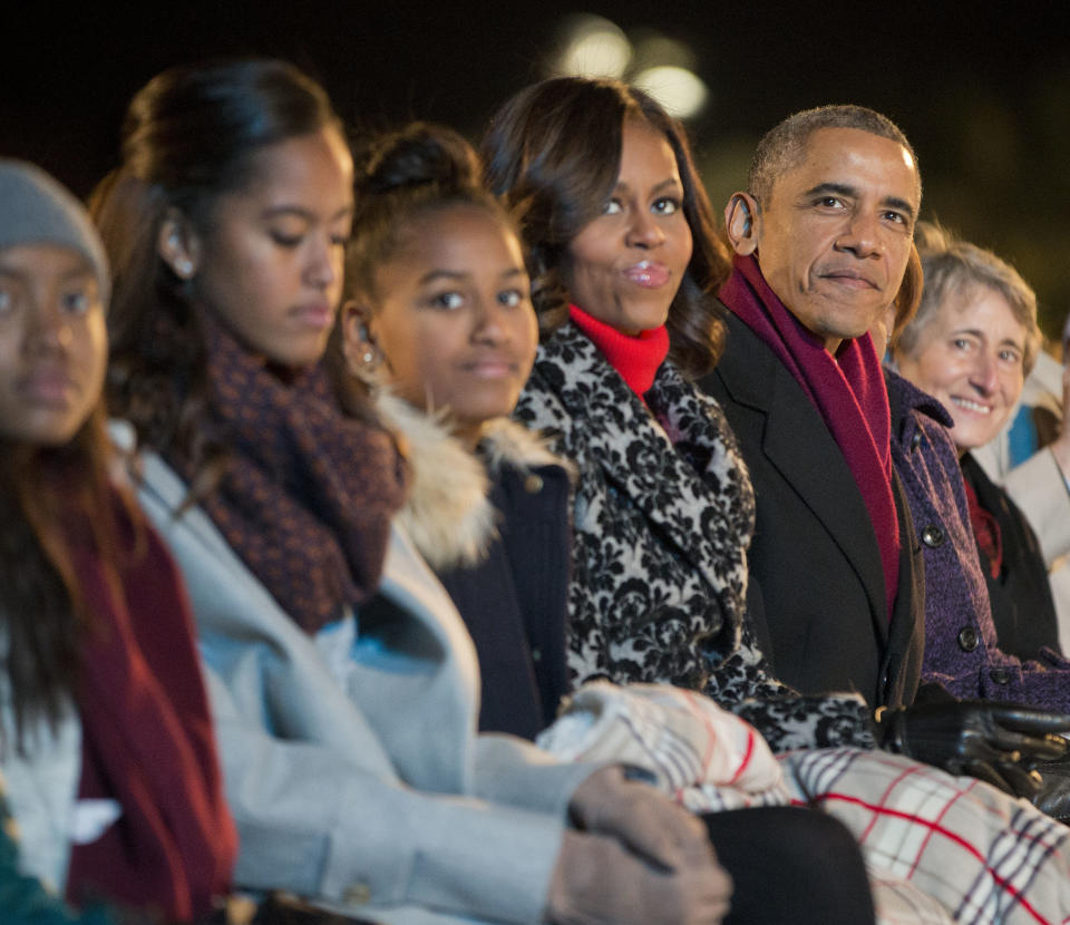 President Barack Obama, with daughters Malia and Sasha and first lady Michelle Obama, watch musical performances at the National Christmas Tree lighting ceremony, Thursday, Dec. 4, 2014, on the Ellipse near the White House in Washington.