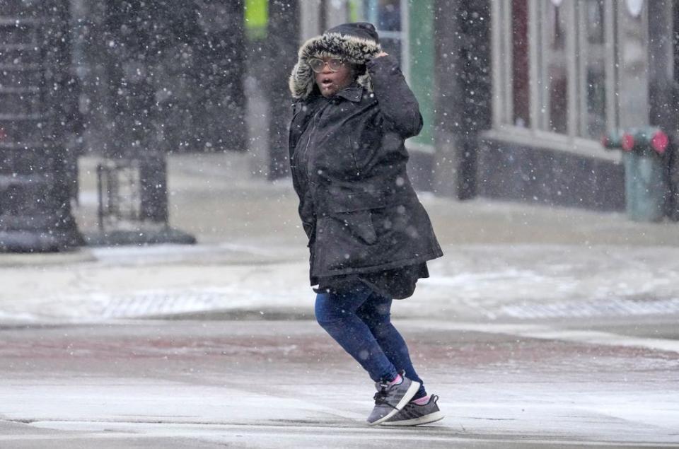 A pedestrian makes their way through the wind and snow across West Wisconsin Avenue at North 6th Street in Milwaukee on Thursday, Dec. 22, 2022. A winter storm was expected to dump several inches of snow on the area  followed by high winds and temperatures in the single digits.