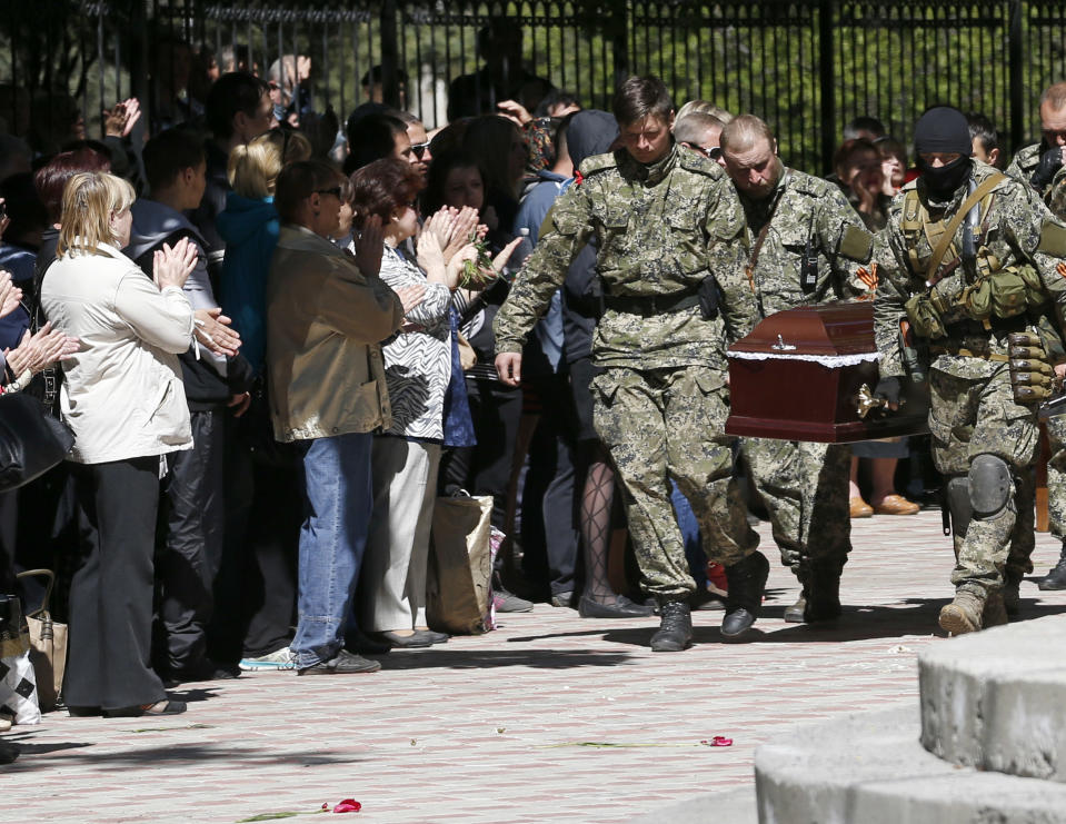 Pro-Russian gunmen carry the coffin of a person killed during clashes last week between Ukrainian and pre-Russian forces, during a commemoration service in the center of Slovyansk, eastern Ukraine, Wednesday, May 7, 2014. The U.S. and European nations have increased diplomatic efforts ahead of Ukraine's May 25 presidential election, as a pro-Russian insurgency continues to rock the country's eastern regions. (AP Photo/Darko Vojinovic)