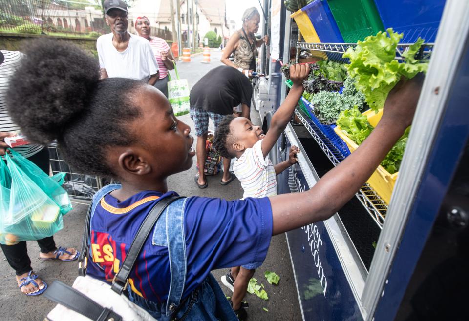 Akirah Skyers, 8, and her brother David, 5, select produce at the Grow! Eat food distribution truck July 14, 2023. The children were visiting the truck with their mother. Grow! Eat distributes food throughout New Rochelle as part of an effort to alleviate food insecurity. Grow! Eat partners with Meals on Main Street, another local non-profit that works to eradicate food insecurity. 