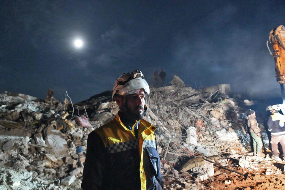 A member of the Syrian civil defence, known as the White Helmets, stand near the rubble of a collapsed building late on Tuesday (RAMI AL SAYED/AFP via Getty Images)