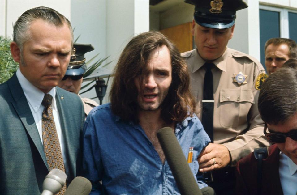 PHOTO: Charles Manson speaks with reporters as he is escorted by a deputy sheriff and his lawyer, Irving Kanarek, from a Santa Monica courthouse following a hearing in the Gary Hinman murder case. (Bettmann Archive/Getty Images, FILE)