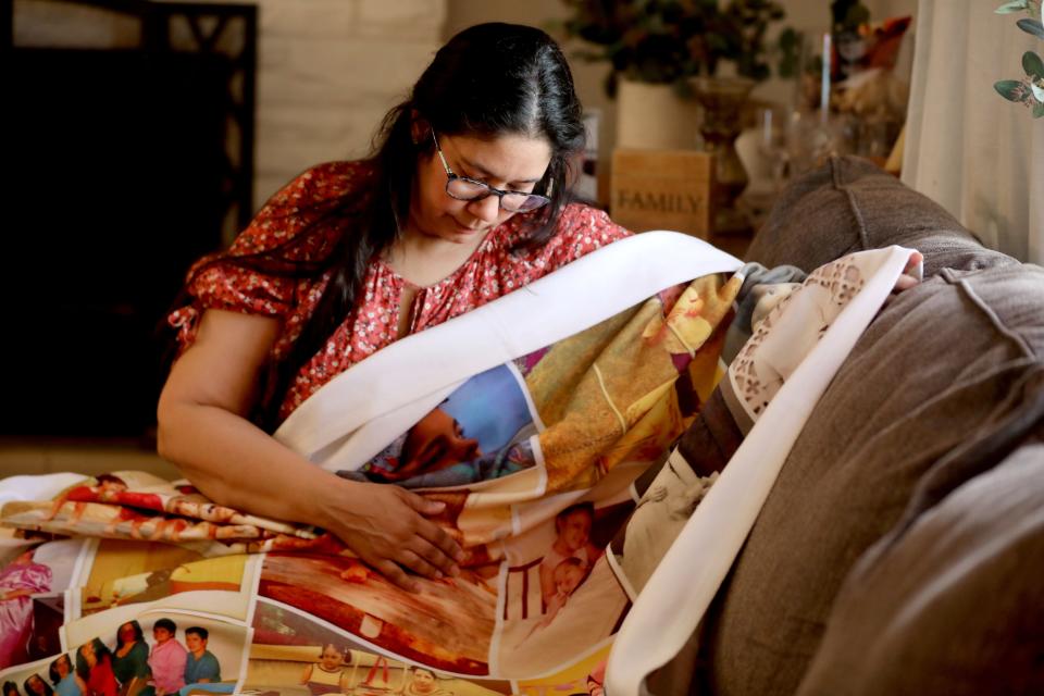 Vivian Zayas of Deer Park, Long Island looks at a blanket with family photos including those of her mother Ana Martinez May 11, 2022. Ana Martinez, 78, died in March of 2020 after contracting COVID-19 during what was to have been a temporary stay a nursing home following knee surgery. Zayas has founded Voices for Seniors, a nonprofit that advocates for residents of nursing homes and their families.