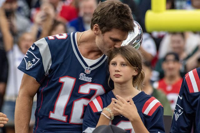 <p>JOSEPH PREZIOSO/AFP via Getty Images</p> Tom Brady kisses daughter Vivian at New England Patriots ceremony honoring the retired quarterback