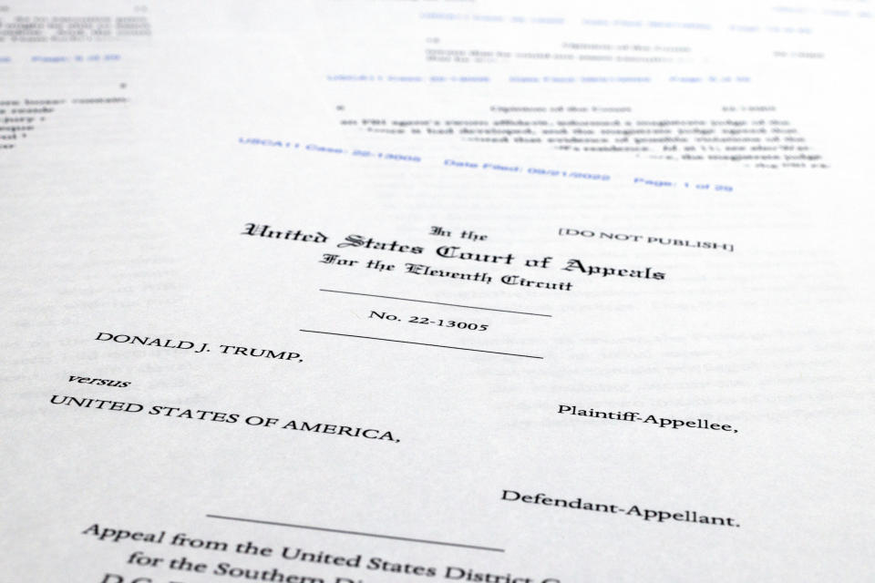 Pages from a U.S. Court of Appeals for the 11th Circuit in Atlanta ruling that lifts a judge's hold on the Justice Department's ability to use classified documents seized by the FBI at Trump's Mar-a-Lago estate, are photographed Wednesday, Sept. 21, 2022. The ruling clears the way for the department to immediately resume its use of the documents in its investigation.(AP Photo/Jon Elswick)