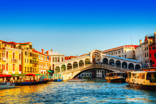 VENICE - DECEMBER 11: Rialto Bridge (Ponte Di Rialto) on a sunny day with tourists on December 11, 2012 in Venice. It's oldest a