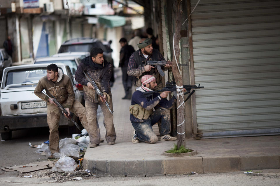 FILE - Syrian rebels take position during clashes with Syrian Army forces in Idlib, north Syria, on March 11, 2012. Syria’s civil war has entered its 14th year on Friday March 15, 2024, a somber anniversary in a long-frozen conflict. The country is effectively carved up into areas controlled by the Damascus government, various opposition groups and Kurdish forces. (AP Photo/Rodrigo Abd, File)