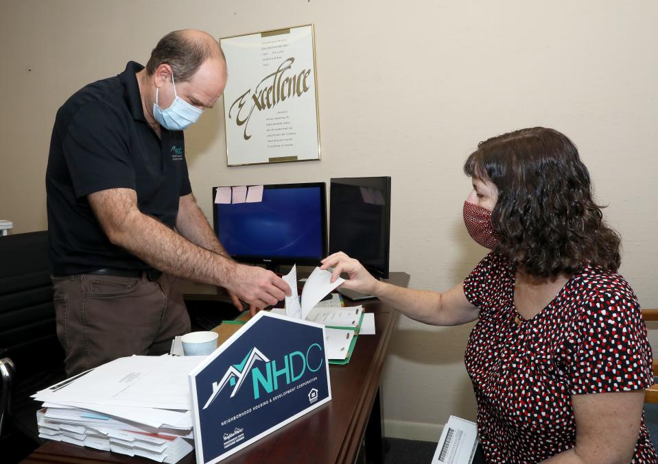 Russ Hirshik, left, a housing counselor, and Anne Conklin, the administrative assistant with the Neighborhood Housing and Development Corp., goes through paperwork in Hirshik's office, on Tuesday in Gainesville.