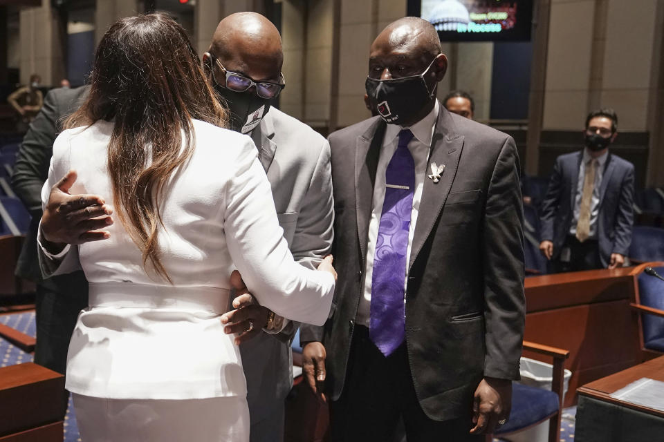 Philonise Floyd, brother of George Floyd, hugs Angela Underwood Jacobs, left, as civil rights attorney Ben Crump. right, looks on during a break in a House Judiciary Committee hearing on proposed changes to police practices and accountability on Capitol Hill, Wednesday, June 10, 2020, in Washington. (Greg Nash/Pool via AP)