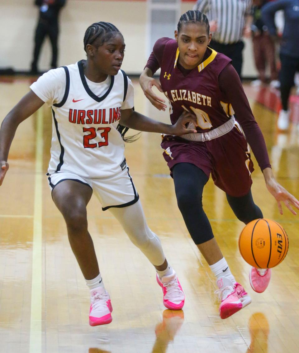 Ursuline's Jezelle Banks (left) defends as St. Elizabeth's Ericka Huggins takes the ball across midcourt on Dec. 5 at Ursuline.