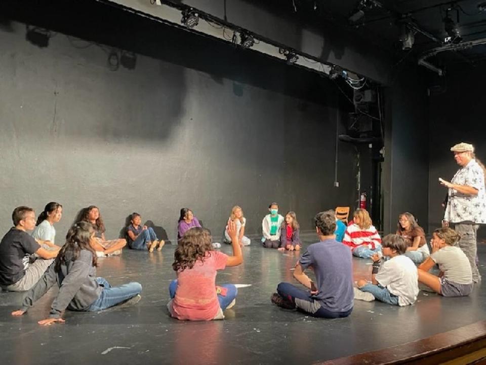 Rob Bosquez, right, directs youth actors at the Rose Maine Theater. Bosquez enjoyed going to the Seminary branch library as a child with his father. Courtesy/Rob Bosquez