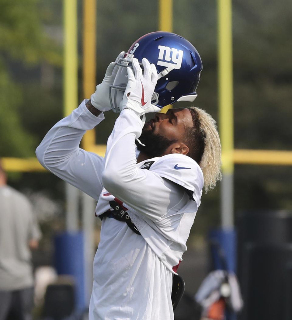 New York Giants receiver Odell Beckham Jr., puts on his helmet before a drill at the Detroit Lions football camp, Wednesday, Aug. 15, 2018, in Allen Park, Mich. (AP Photo/Carlos Osorio)