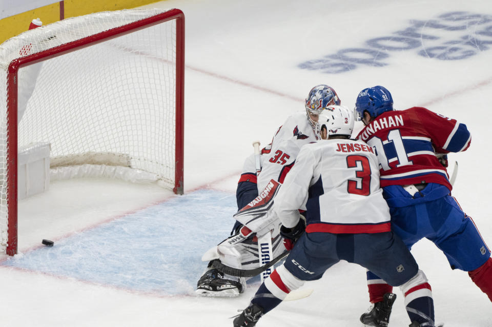 Montreal Canadiens' Sean Monahan (91) scores on Washington Capitals goaltender Darcy Kuemper (35) and Nick Jensen (3) during the first period of an NHL hockey game in Montreal on Saturday, Oct. 21, 2023. (Christinne Muschi/The Canadian Press via AP)