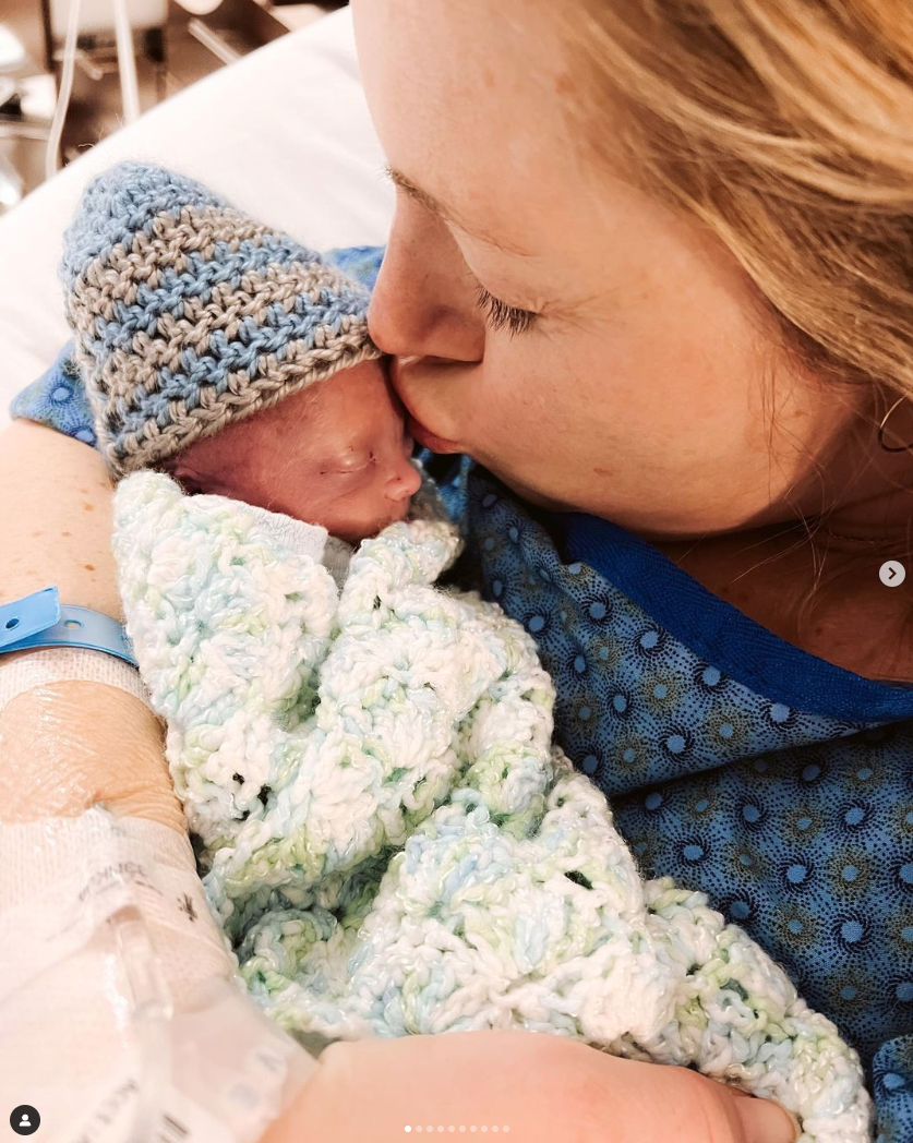 sarah herron, in the hospital, kissing the forehead of baby