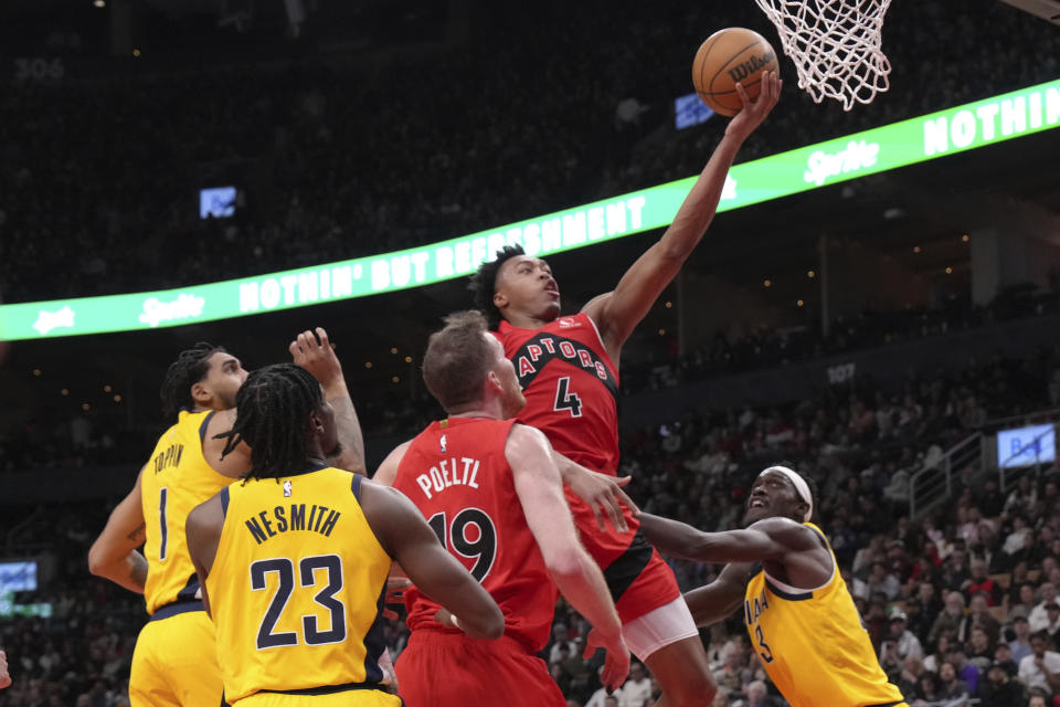Toronto Raptors' Scottie Barnes scores as Indiana Pacers' Pascal Siakam, right, watches during the first half of an NBA basketball game Wednesday, Feb. 14, 2024, in Toronto. (Chris Young/The Canadian Press via AP)