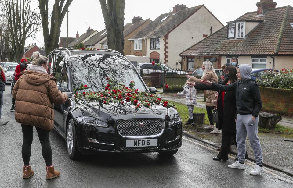 Members of the public place red roses on the hearse of Olly Stephens (PA) (PA Wire)