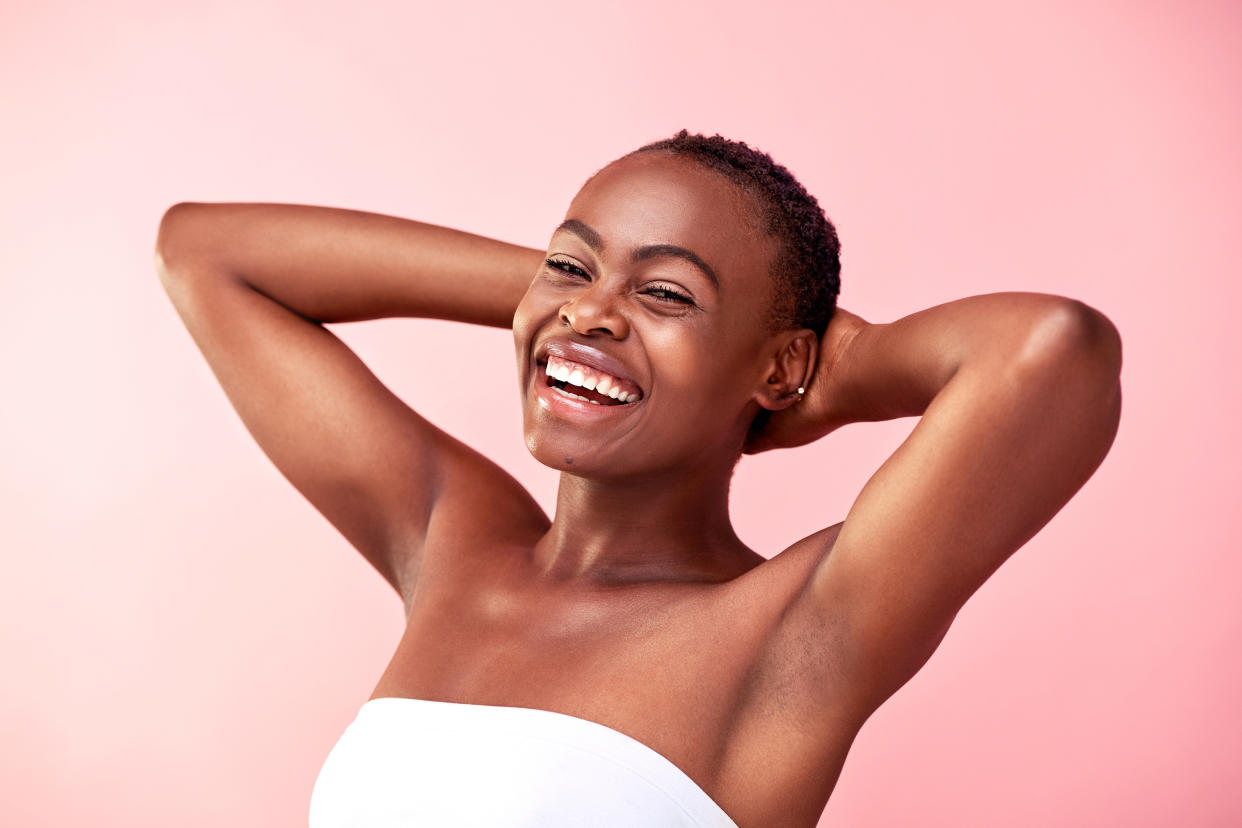 Studio shot of a beautiful young woman posing against a pink background