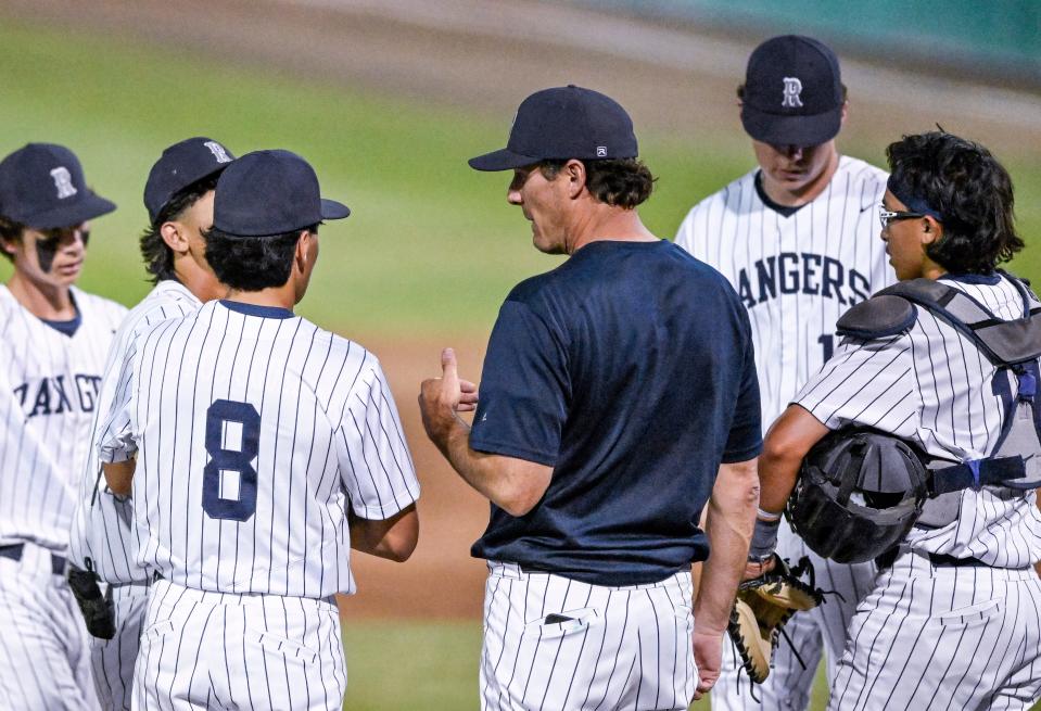 Redwood pitching coach Adam Pettyjohn talks with infield players during the game against Mt. Whitney in an East Yosemite League high school baseball game at Valley Strong Ballpark on Friday, April 19, 2024.