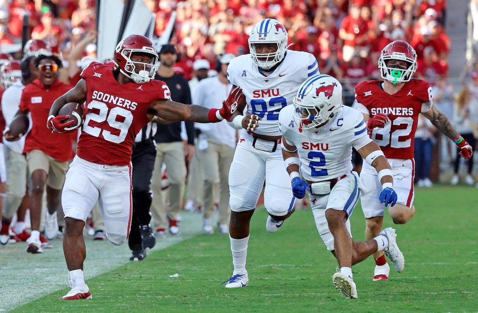 OU's Tawee Walker (29) tries to get by SMU's Jonathan McGill (2) and Kori Roberson (92) in the first half last Saturday in Norman.