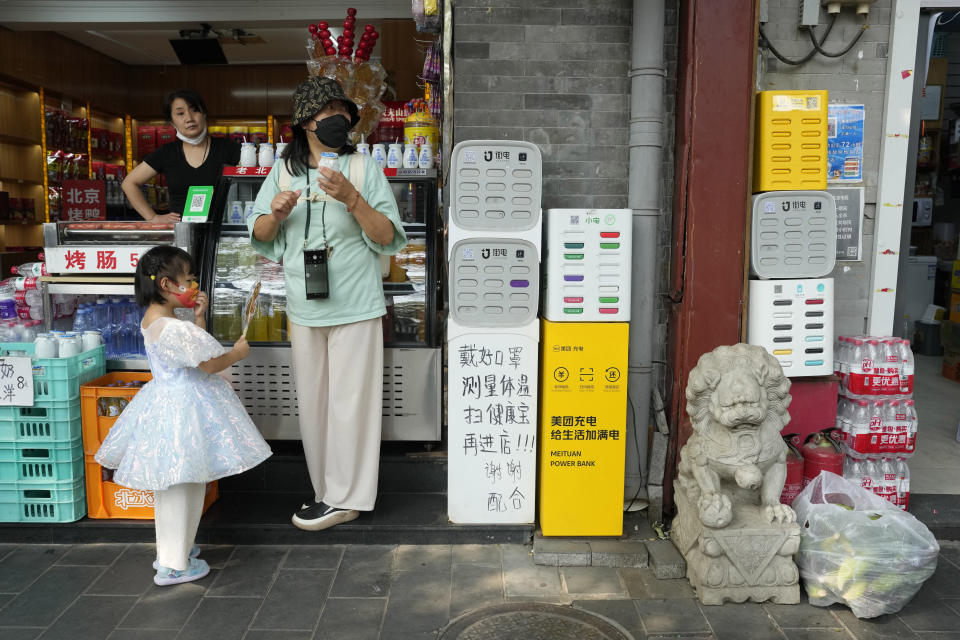 A child holds up a candy at a convenience store in Beijing on Sept. 29, 2022. A meeting of the ruling Communist Party to install leaders gives President Xi Jinping, China's most influential figure in decades, a chance to stack the ranks with allies who share his vision of intensifying pervasive control over entrepreneurs and technology development. (AP Photo/Ng Han Guan)