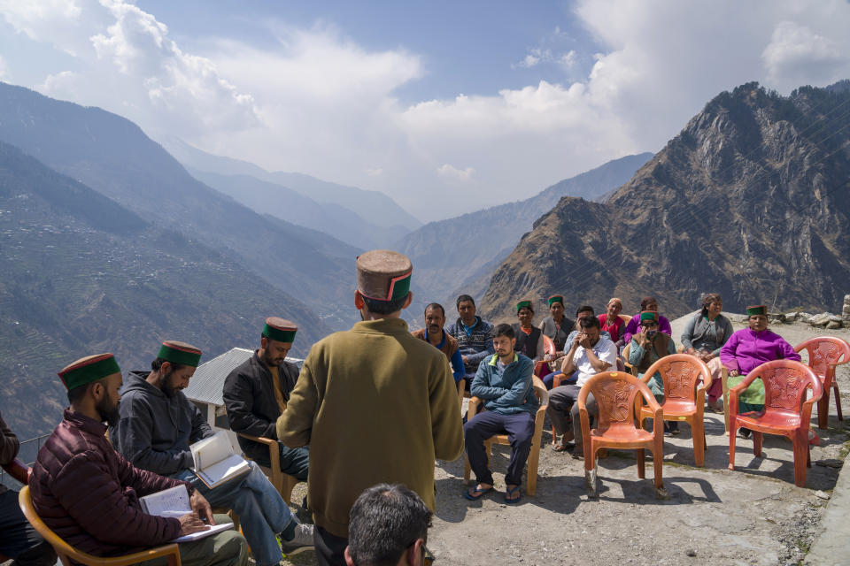 Activists exchange information with the residents of Kandar, a remote village that had to be resettled after rockslides damaged houses, in Kinnaur district of the Himalayan state of Himachal Pradesh, India, Sunday, March 12, 2023. In past years resentment against the hydroelectric dams has grown, mirroring concerns across the environmentally sensitive Himalayas about building dams with inadequate assessments. (AP Photo/Ashwini Bhatia)