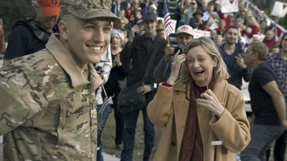 In this undated photo provided by Anheuser-Busch, Lt. Chuck Nadd, left, is greeted by his mother after he rode aboard the famously-red Budweiser beer wagon in a parade, led by a marching band through Winter Park, Fla. The brewer has fashioned an ad around the parade that will run during the Super Bowl(AP Photo/Anheuser-Busch, Hand Out)