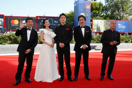 Director Hirokazu Koreeda (L) poses with actors Suzu Hirose (2nd L), Masaharu Fukuyama (C), Koji Yakusho and composer Ludovico Einaudi (R) during a red carpet for the movie "The third murder". REUTERS/Alessandro Bianchi