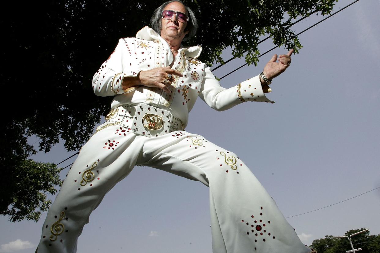 Elvis fan Tom Elliott from Illinois poses for a photo at Graceland Crossing during Elvis Week 2005