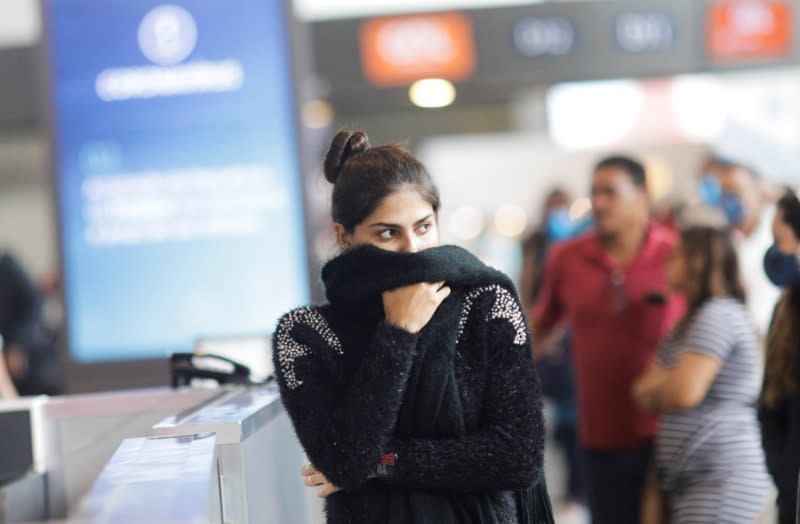 A passenger covers her face as she walks at Galeao international airport during the coronavirus disease (COVID-19) outbreak in Rio de Janeiro