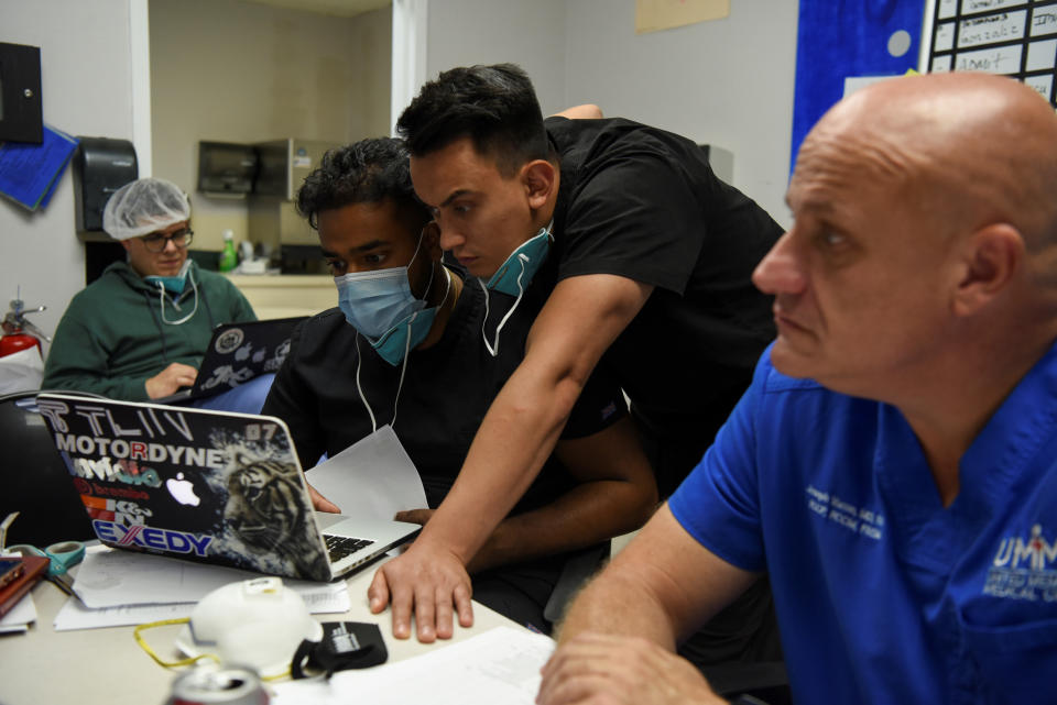 Sanathan Aiyadurai, 27, and Diego Montelongo, 27, who are medical students, review a COVID-19 patient's status during a daily meeting lead by Dr. Joseph Varon, 58, the chief medical officer at United Memorial Medical Center (UMMC), during the coronavirus disease (COVID-19) outbreak, at UMMC in Houston, Texas, U.S., July 10, 2020.  REUTERS/Callaghan O'Hare     SEARCH "COVID-19 HOUSTON VARON" FOR THIS STORY. SEARCH "WIDER IMAGE" FOR ALL STORIES.