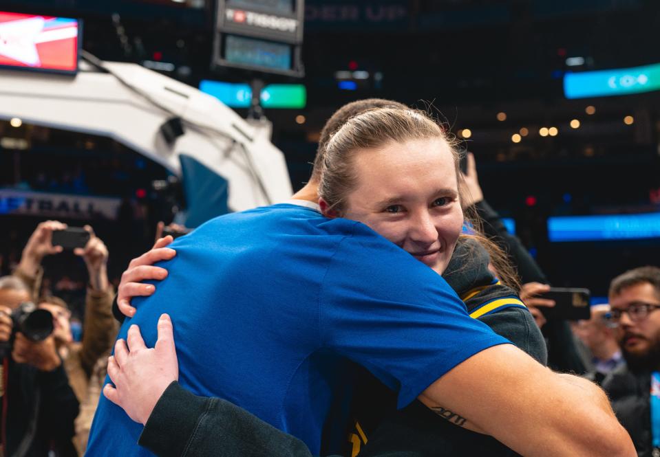 Golden State Warriors star Stephen Curry hugs OU women's basketball player Taylor Robertson before Monday's NBA game between the Thunder and Warriors at Paycom Center.