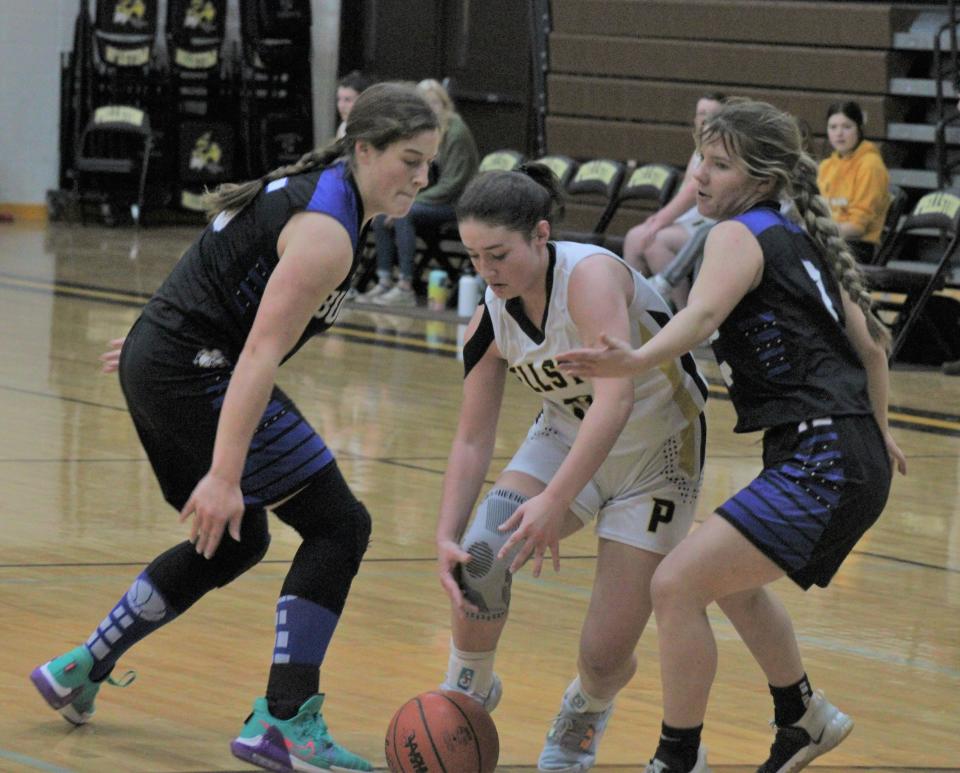 Pellston freshman Breanna Willis (middle) slices through Inland Lakes defenders Natalie Wandrie (left) and Lauren Fenstermaker (right) during the first half on Friday.