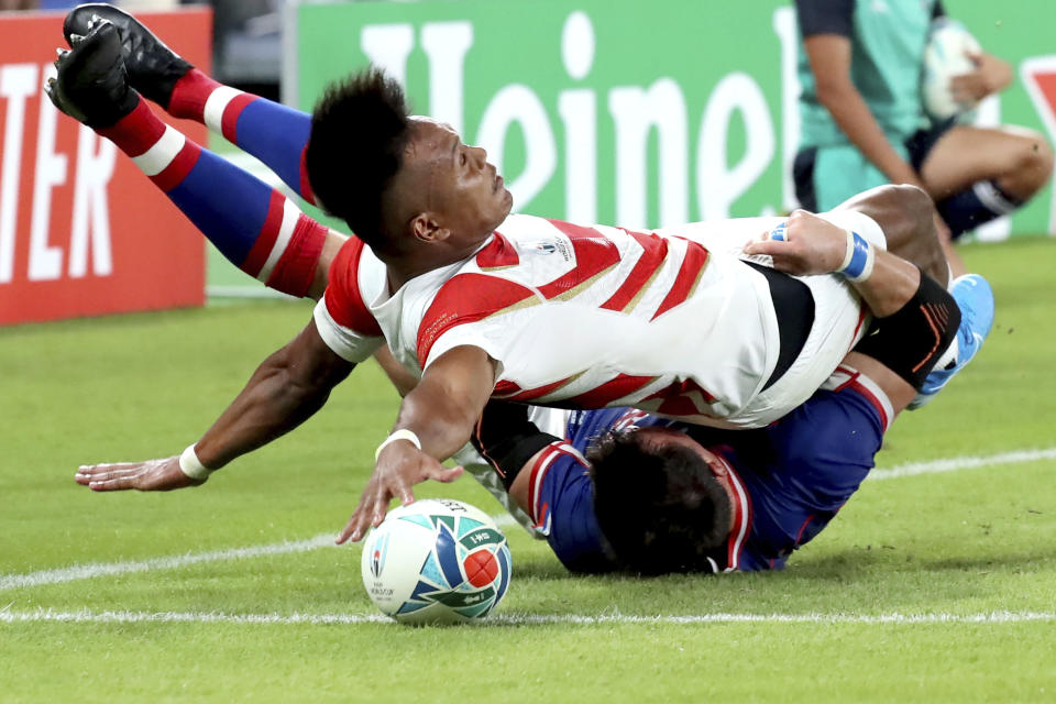 Japan's Kotaro Matsushima, top, makes an attempt to score a try, tackled by Russia's Vasily Artemyev during the Rugby World Cup Pool A game at Tokyo Stadium between Russia and Japan in Tokyo, Japan, Friday, Sept. 20, 2019. The try was disallowed by video referee.(AP Photo/Eugene Hoshiko)