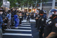 FILE- In this June 3, 2020 file photo, protesters confront New York Police officers as part of a solidarity rally calling for justice over the death of George Floyd, in the Brooklyn borough of New York. Concerned about people packed in tightly during the recent protests, New York Gov. Andrew Cuomo says the thousands of people protesting the death of George Floyd have a "civic duty" to be tested for the coronavirus. (AP Photo/Frank Franklin II)