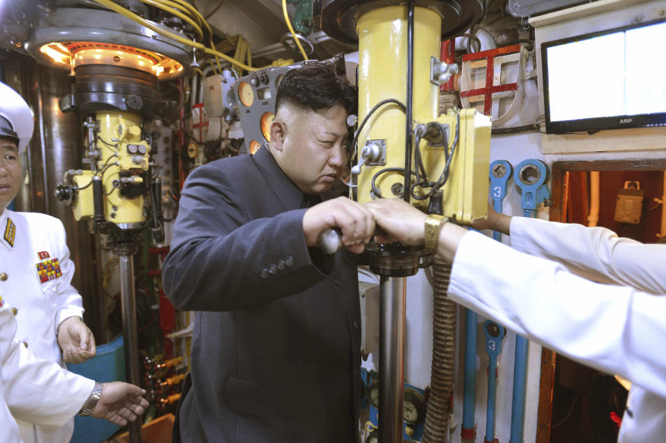 North Korean leader Kim Jong Un (C) looks through a periscope of a submarine during his inspection of the Korean People's Army (KPA) Naval Unit 167 in this undated photo released by North Korea's Korean Central News Agency (KCNA) in Pyongyang June 16, 2014. REUTERS/KCNA (NORTH KOREA - Tags: POLITICS MILITARY MARITIME)  ATTENTION EDITORS - THIS PICTURE WAS PROVIDED BY A THIRD PARTY. REUTERS IS UNABLE TO INDEPENDENTLY VERIFY THE AUTHENTICITY, CONTENT, LOCATION OR DATE OF THIS IMAGE. FOR EDITORIAL USE ONLY. NOT FOR SALE FOR MARKETING OR ADVERTISING CAMPAIGNS. THIS PICTURE IS DISTRIBUTED EXACTLY AS RECEIVED BY REUTERS, AS A SERVICE TO CLIENTS. NO THIRD PARTY SALES. NOT FOR USE BY REUTERS THIRD PARTY DISTRIBUTORS. SOUTH KOREA OUT. NO COMMERCIAL OR EDITORIAL SALES IN SOUTH KOREA